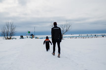 father and son walking through snow 