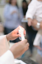 priest lighting a baptismal candle 