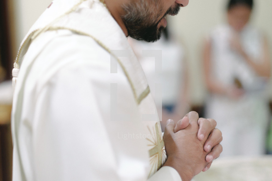 a priest with praying hands 