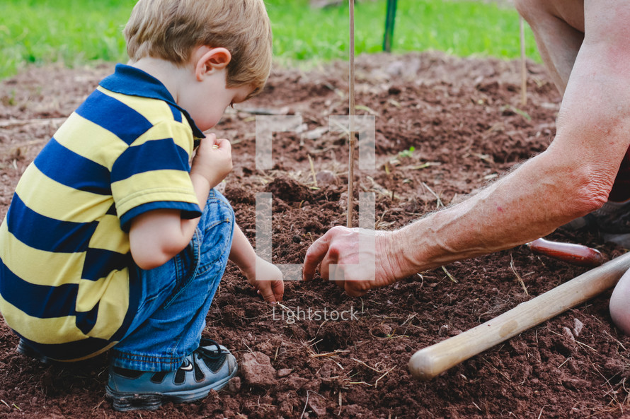 grandfather and grandson planting seeds 