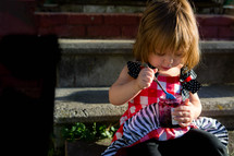 a toddler girl eating jam 