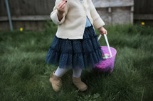 a little girl eating candy during an Easter egg hunt 