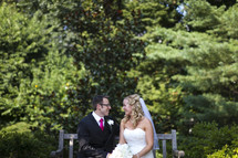 Happy bride and groom sitting on bench