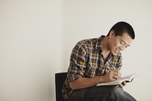 An Asian man reading and studying his Bible
