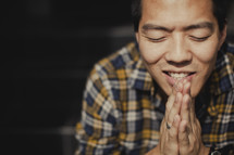A man with hands touching in prayer