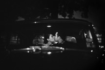 man and woman kissing in a car