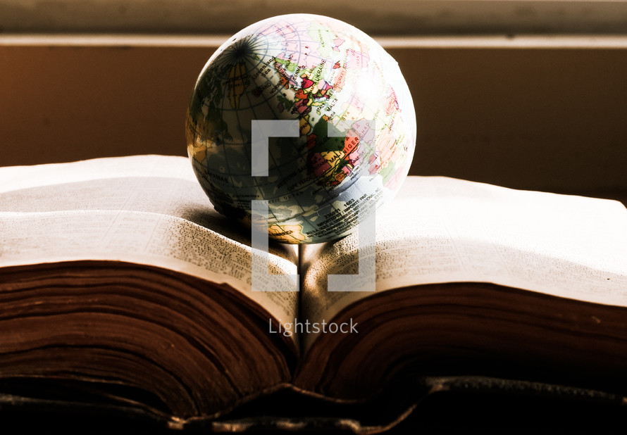 a globe on the pages of a Bible 