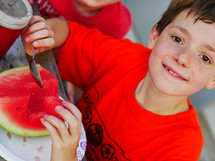 a boy child eating a watermelon 
