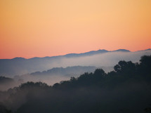 fog over a mountain at sunrise 