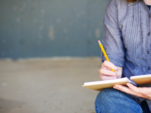 a teen writing in a journal 