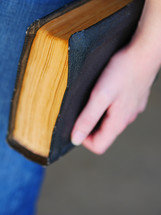 a woman holding a Bible at her side 