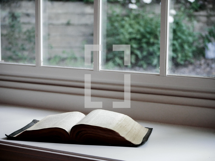 a Bible in a window sill 