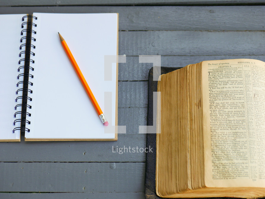 pencil on a journal and open Bible 