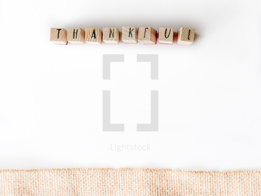 word thankful on a white background and burlap border 