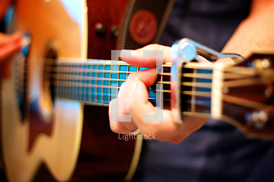 hand around the neck of a guitar 