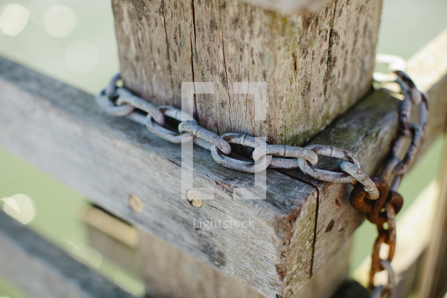 Rusty chain around fence post