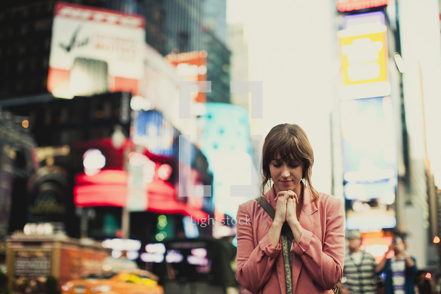 Woman praying in the city
