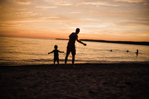 father and son on a beach at sunset 