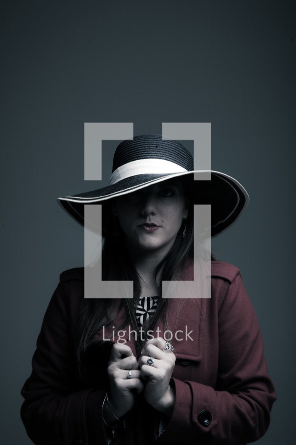 woman in a hat and trench coat posing 