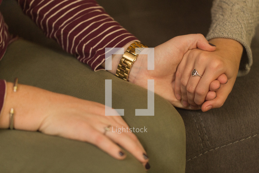 teen girls holding hands in prayer at a Bible study 