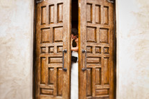 bride and groom kissing behind doors
