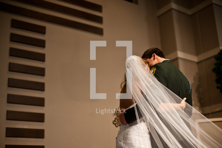 bride and military groom kissing 