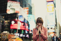 Woman praying in the city