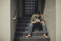 Man sitting on stairs praying 