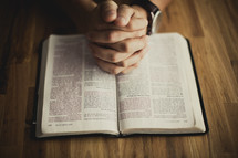 A man praying while reading his Bible