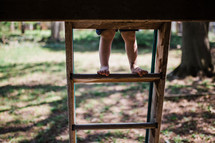 child's feet on a ladder 