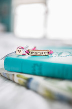 mama bracelet on a stacks of books 