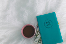 mug, Bible, and journal on a bed 