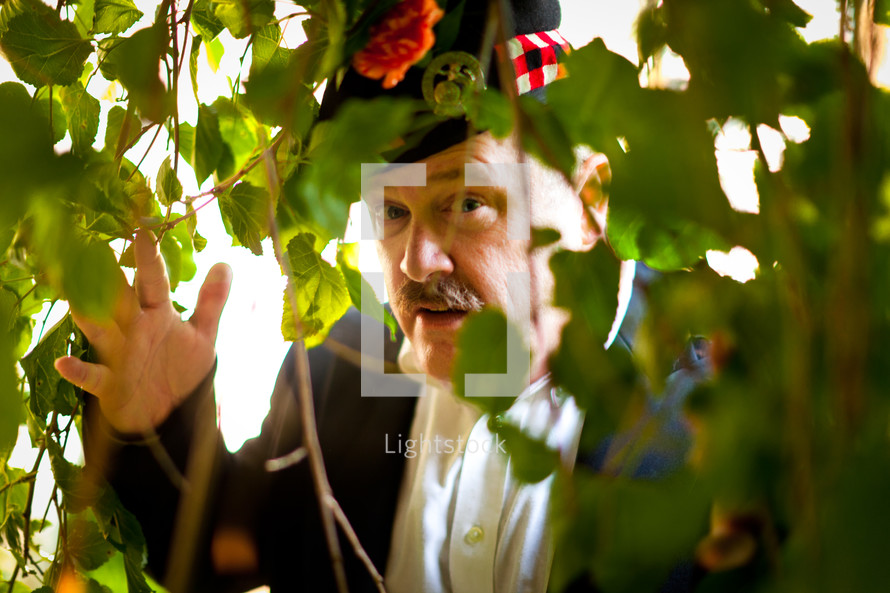 scottish kilt man peeking through ivy 