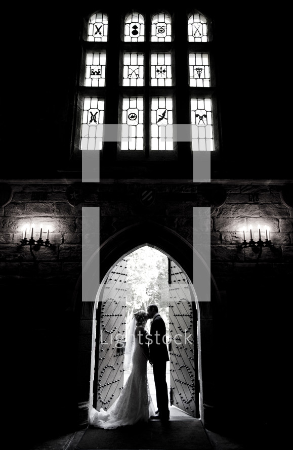 bride and groom kissing in the doorway 