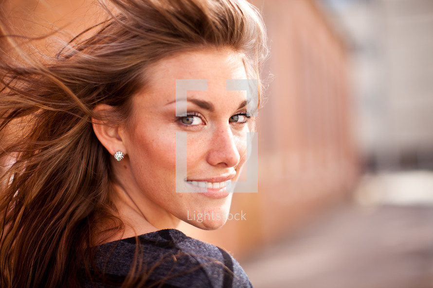 smiling woman with her hair blowing