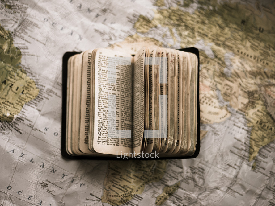 open Bible on a world map 