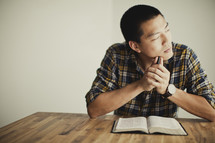 An asian man thinking about scripture
