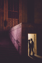 Couple standing in doorway holding hands