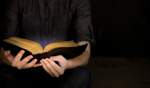 a woman holding an open Bible 