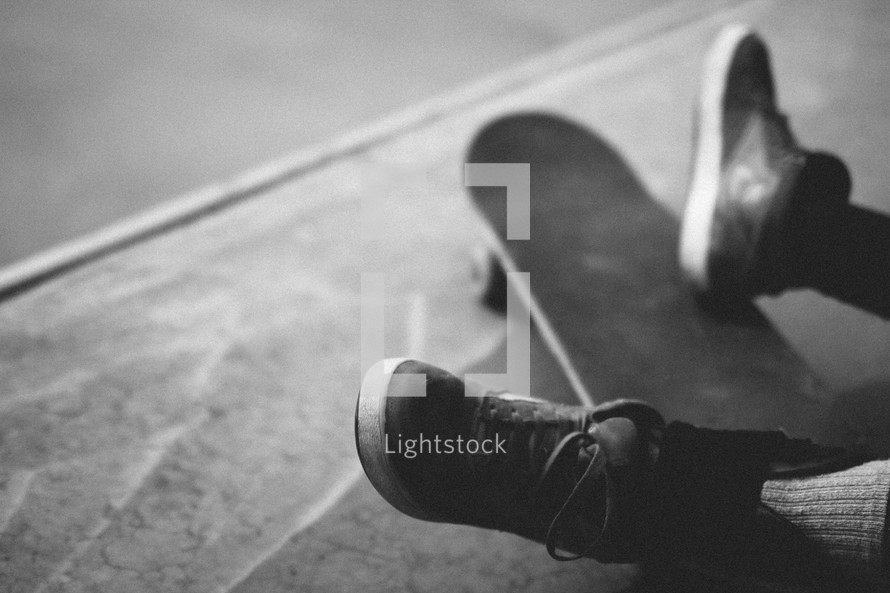 feet resting on a skateboard 