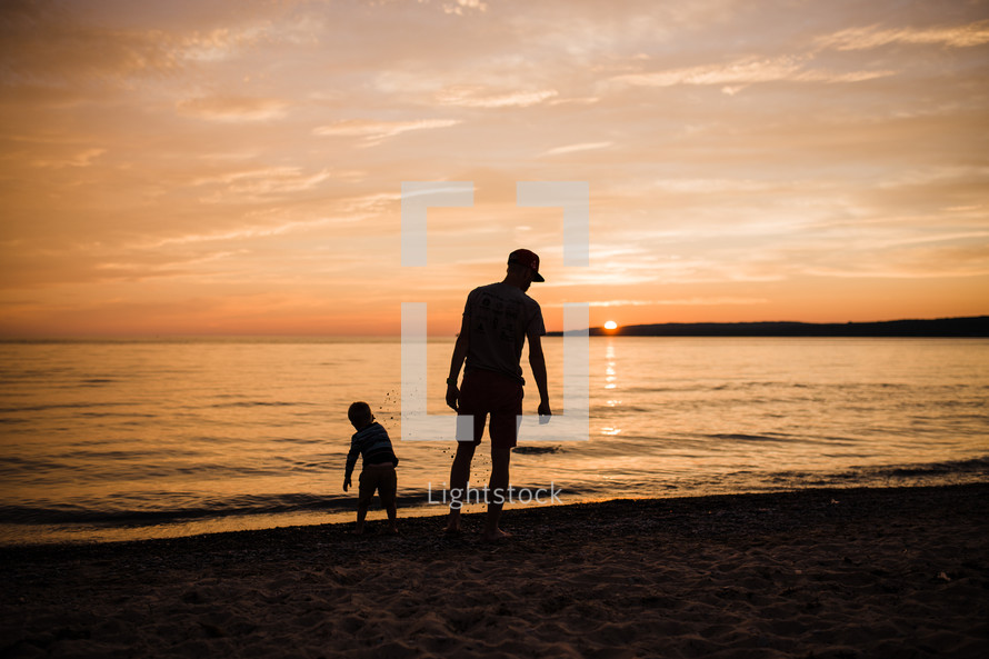 father and son on a beach at sunset 
