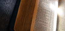 cross light on the pages of a Bible 