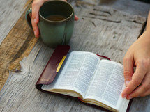 reading a pocket Bible and drinking coffee 