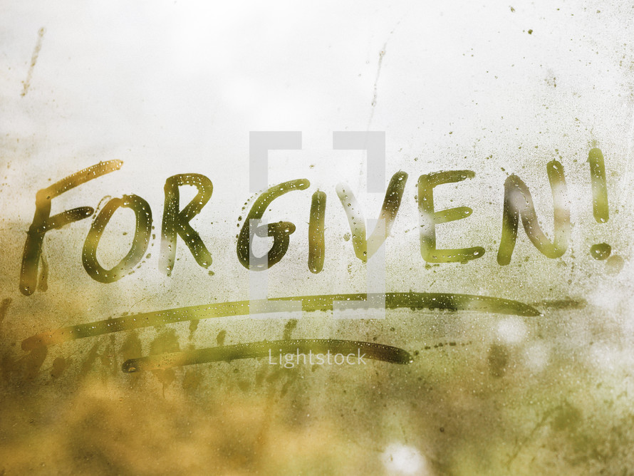 the word forgiven written on fogged glass 