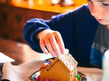 decorating a gingerbread house at Christmas 