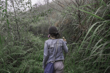 a woman hiking through a dense forest