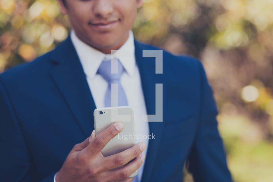 man in a suit checking his cellphone 