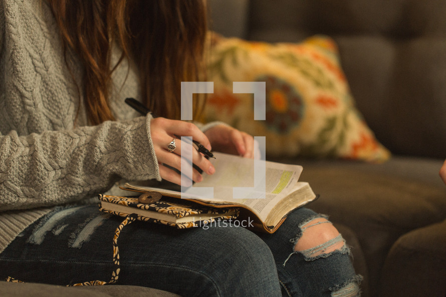 teen girl reading a Bible at a Bible study 