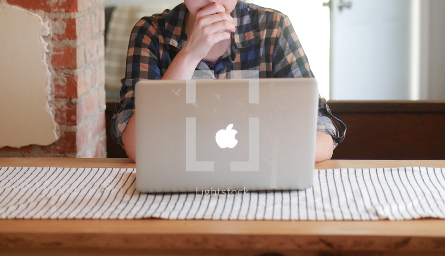 young man behind a laptop screen 