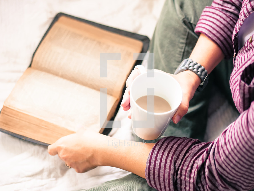a woman drinking coffee and reading a Bible in bed 